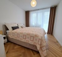 A bedroom with a double bed and a wooden decor floor in a 3-room apartment.