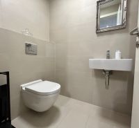 A toilet with a sink and a mirror in a 2-room apartment, beige tiles.