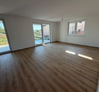 Interior of a family house with large windows and a wooden decor floor.