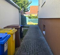 Family house on Kupeckého Street in Piešťany, waste bins, narrow sidewalk.