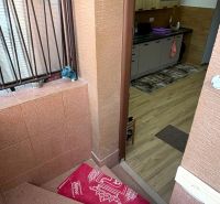 Stairs and a kitchen with wood-patterned flooring in a family house.