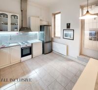 Kitchen in a 2-room apartment with white cabinets, appliances, and tiles.