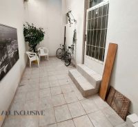 A hallway with chairs in a 2-room apartment with a bicycle and a picture of Paris.