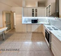 A kitchen with a white cabinet and a dining table in a 2-room apartment.