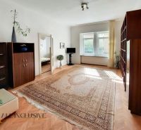 Living room in a 2-room apartment with a carpet and a floor with a wooden decor.