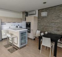 A kitchen in a 3-room apartment with a wooden decor floor and a dining table.
