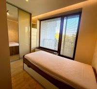 A bedroom with a wood-patterned floor and a built-in wardrobe in a 3-room apartment.