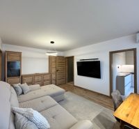 Living room in a 3-room apartment with a wooden decor floor and modern furniture.