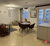 Open living space with a dining table and cream tiles in a 3-room apartment.