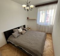 A bedroom with a double bed and a wooden decor floor in a 3-room apartment.