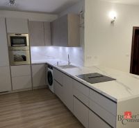 A kitchen in a 3-room apartment with a marble countertop and a floor with a wood decor.