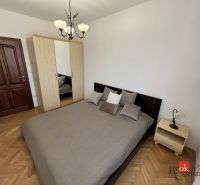 Bedroom in a 3-room apartment with a double bed and a wardrobe, floor with wooden decor.