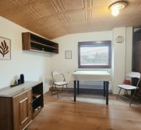 Interior of a holiday apartment with wooden decor furniture and folding chairs.