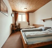 Bedroom in a Holiday Apartment with two beds and a TV, floor with wooden decor.