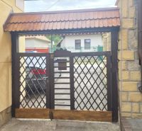 A gate with a lattice pattern leading to the courtyard on Hlboká Street in Podhájska.