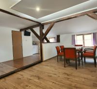 Dining room with wooden beams and a floor with a wooden decor in the Holiday Apartment.