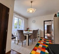 A dining room in a family house with a cheerful carpet design and a wooden floor design.