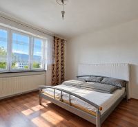 A bedroom in a family house with a bed and a wooden decor floor.