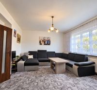 Living room in a family house with a large sofa and a striking carpet.