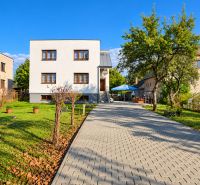 A family house in Martin with a driveway and a garden, surrounded by greenery and trees.