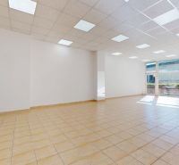 Spacious commercial premises illuminated by daylight with tiled flooring.