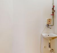 White wall with a sink and faucet in commercial premises.