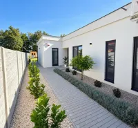 A family house in Čierna Voda on Čierna Voda Street with a paved walkway and greenery.