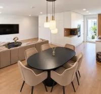 Interior of a family house with furniture, light-colored walls, and a floor with a wood design.