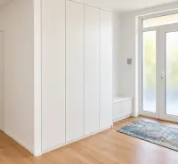Entrance area in a family house with a wooden decor floor and a built-in wardrobe.