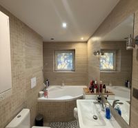 Bathroom in a 2-room apartment with a bathtub, sink, and washing machine, tiled with tiles.