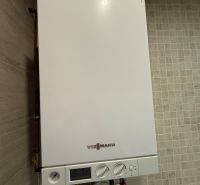 Condensing boiler of the Viessmann brand in the interior of a 2-room apartment on beige tiles.
