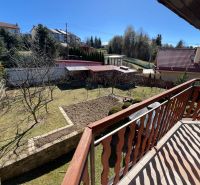 View from the balcony of a family house in Stará Ľubovňa, garden with lawn and trees.