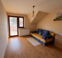 Interior of a room in a family house with a wooden decor floor and a sofa.