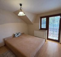 A bedroom in a family house with a bed and a wooden decor floor.
