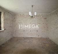 Room in a family house with exposed brick walls and a pendant light.