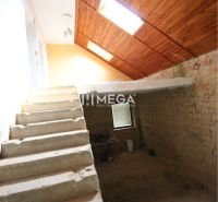 Staircase and attic with wooden ceiling paneling in a family house.