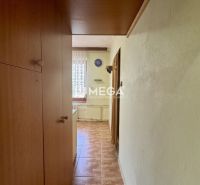 A hallway in a 2-room apartment with a ceramic floor and wooden cabinets.