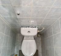 A toilet with blue tiles in a 2-room apartment, simple interior.