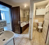Bathroom in a 3-room apartment with tiles and white sanitary ware.