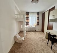 A room with a carpet, a bunk bed, a desk, and a chair in a three-room apartment.