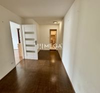 A hallway in a 3-room apartment with white doors and a floor with a wooden design.