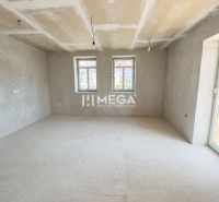 A spacious room in a family house with large windows and a concrete floor.