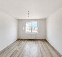 A bright empty space with white walls and a wooden decor floor in a 2-room apartment.