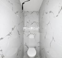 A bathroom in a 2-room apartment with marble tiles.