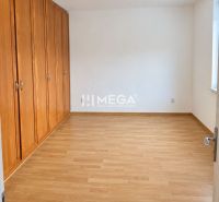 A bedroom in a 2-room apartment with a wooden decor floor and built-in wardrobes.