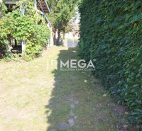 A garden at a family house on Kudlovska Street in Humenné, bordered by climbing plants and a fence.