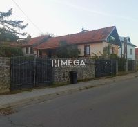 A family house on Kudlovská Street in Humenné with a stone fence and a red roof.