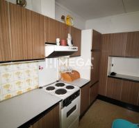 A kitchen in a family house with wooden decor kitchen cabinets and tiles with a floral pattern.
