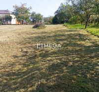 A grassy plot in Humenné for residential purposes, surrounded by greenery and trees.