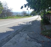 Street view in Humenné on residential plots, with a road and a sidewalk.